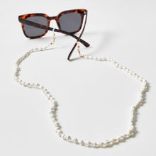 Load image into Gallery viewer, Brillenkette / Maskenkette mit weißen Muscheln an einer Sonnenbrille